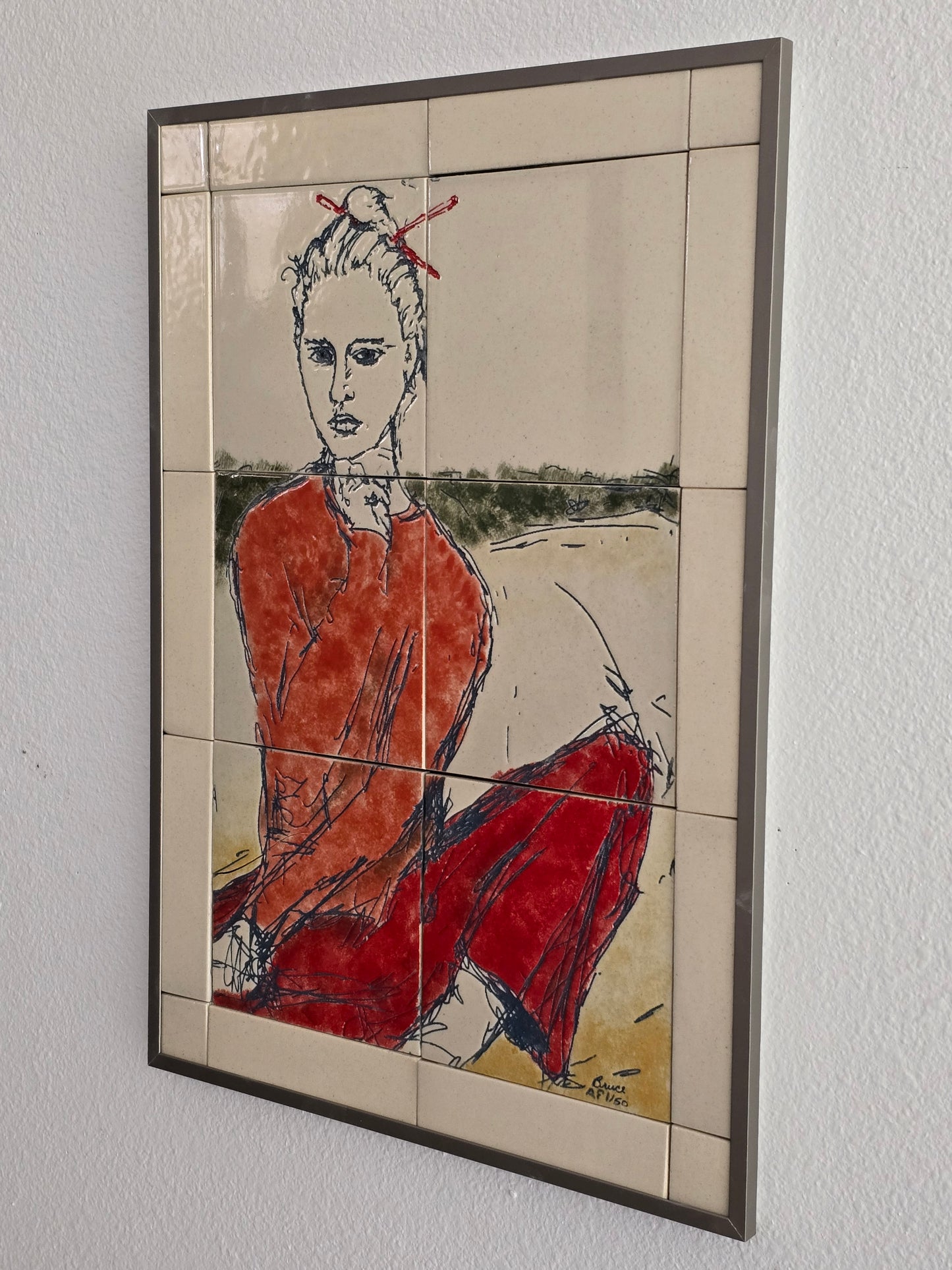 This is a side view of a set of 20 mounted and framed tiles depicting a woman with chopsticks. The woman is dressed in la light red sweatshirt and red pants. 
The tiles are made of cream-colored porcelain. they are mounted on a waterproof board and framed with an aluminum frame.