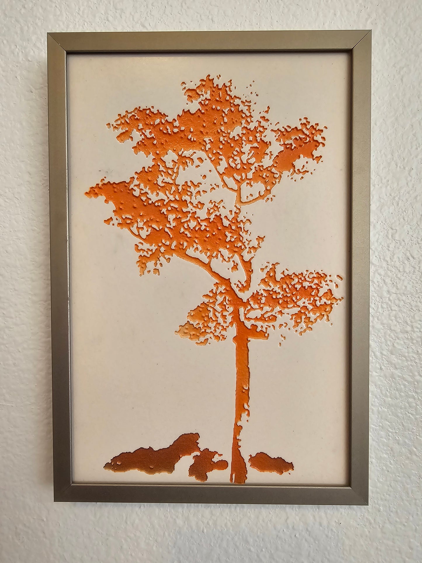 This is a photo showing the front view of Tree #1 - Orange hanging on a wall. 