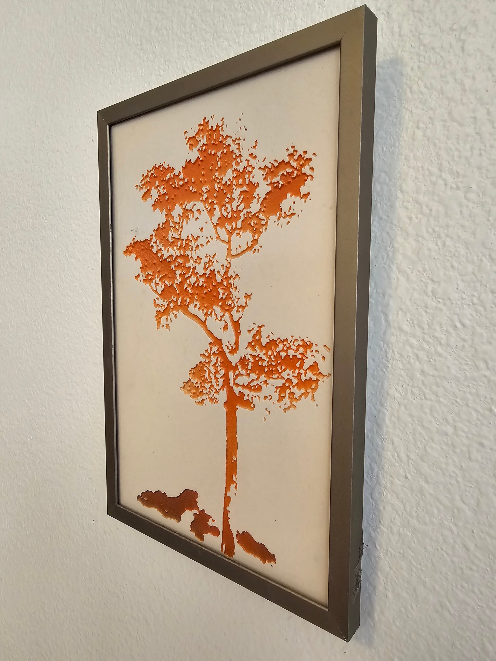 This is a photo showing the side view of Tree #1 - Orange hanging on a wall. This view is included to show the indented areas of the tree pattern.  