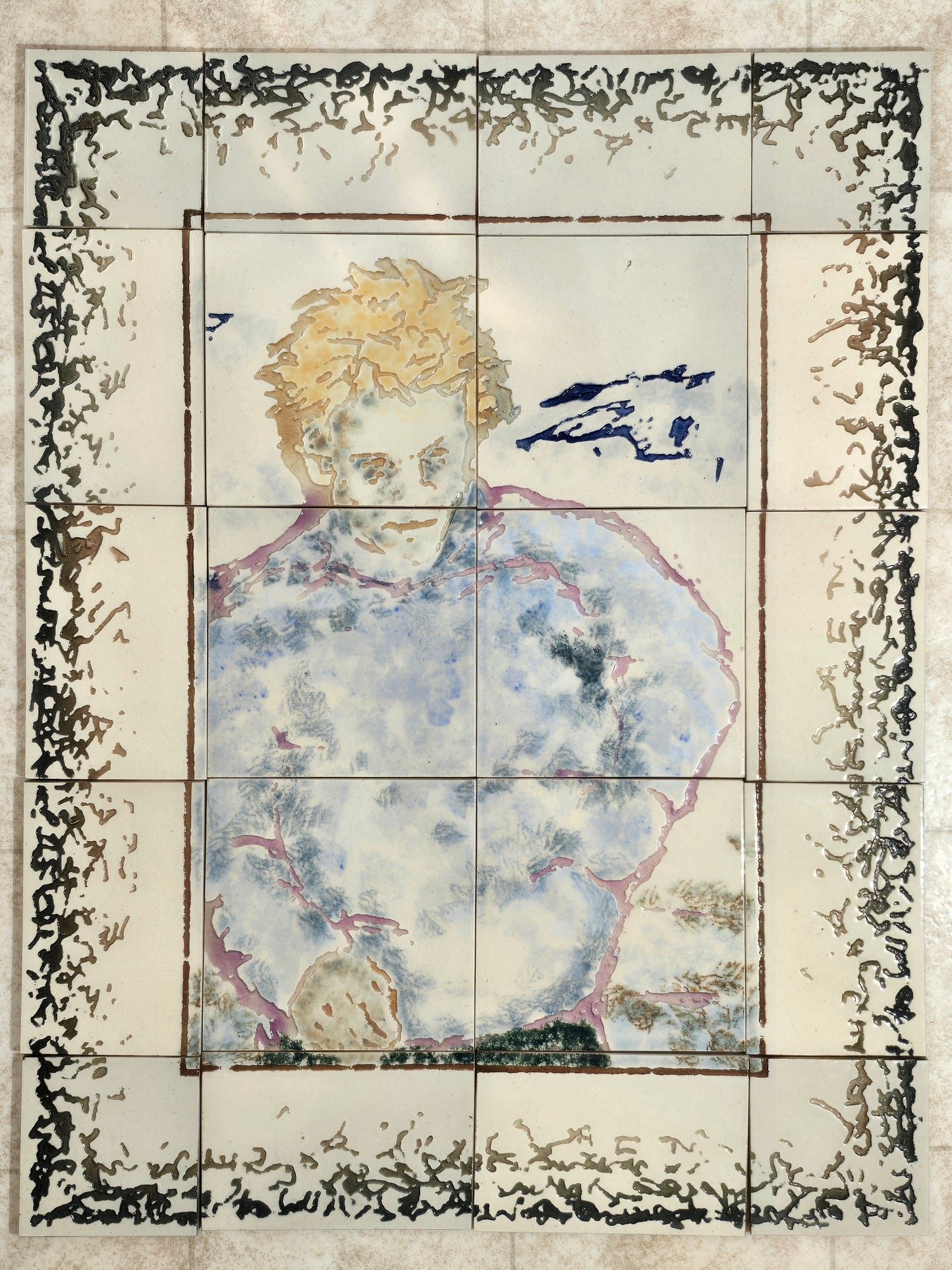 This vie shows the image of a boy with yellow hair and a fuzzy blue jacket with purple outline. The border tiles graduate in color from a green outer edge to a brown inner area. 